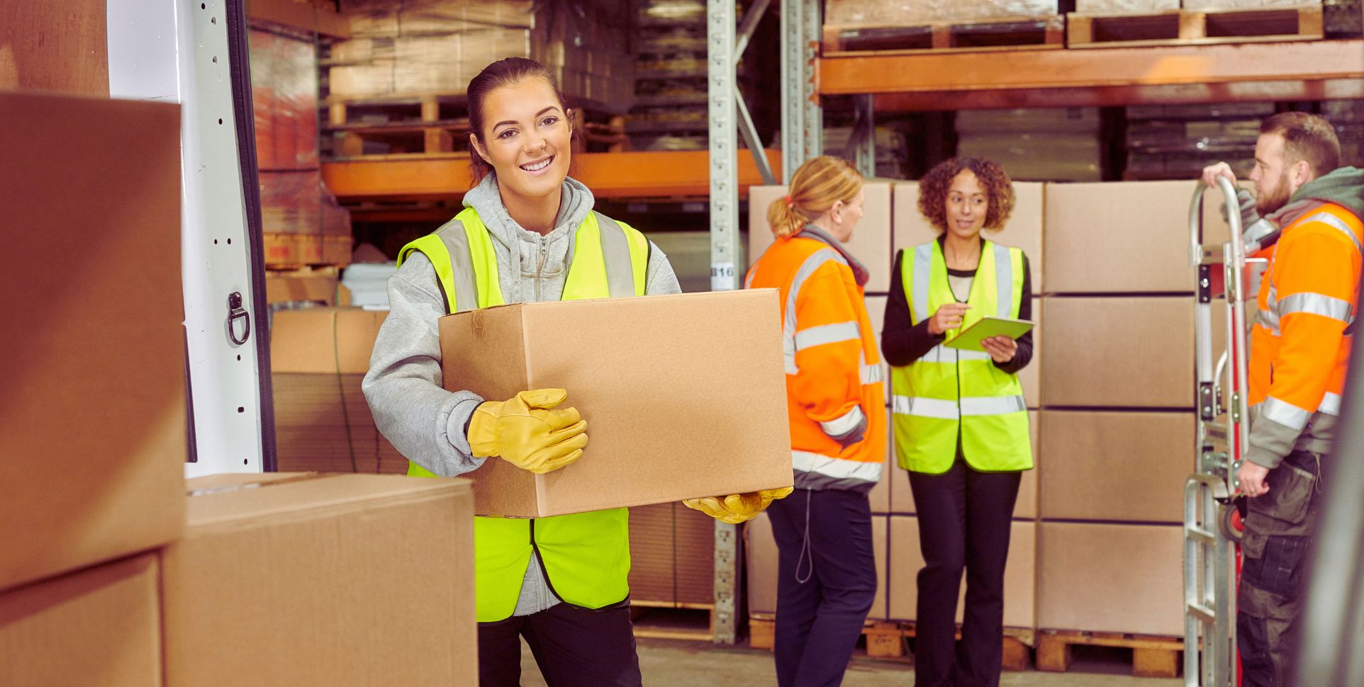 Swift Transport Services workers in high-visibility vests organise an industrial Melbourne warehouse, ensuring reliable transport.